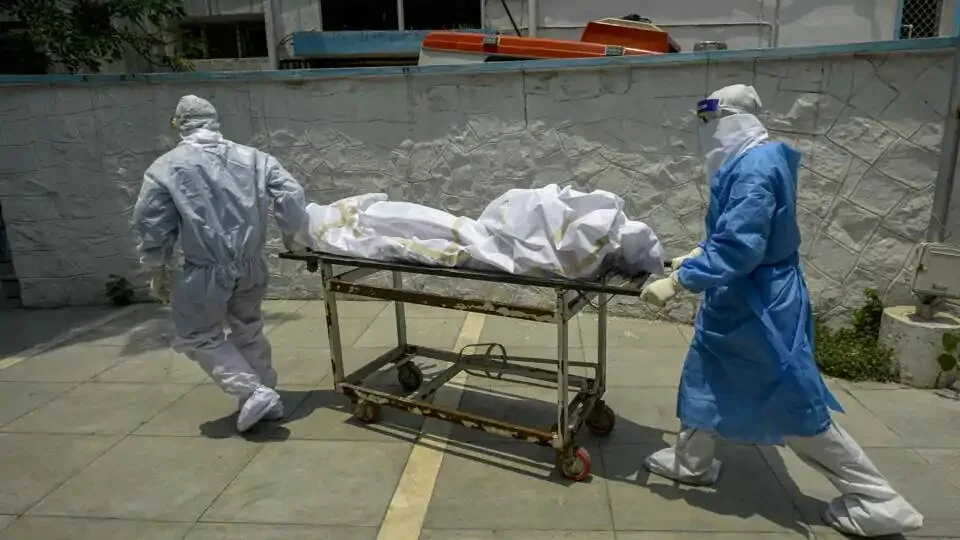 Medical professionals wearing PPE coveralls escorts the body of a coronavirus victim at a hospital in New Delhi.