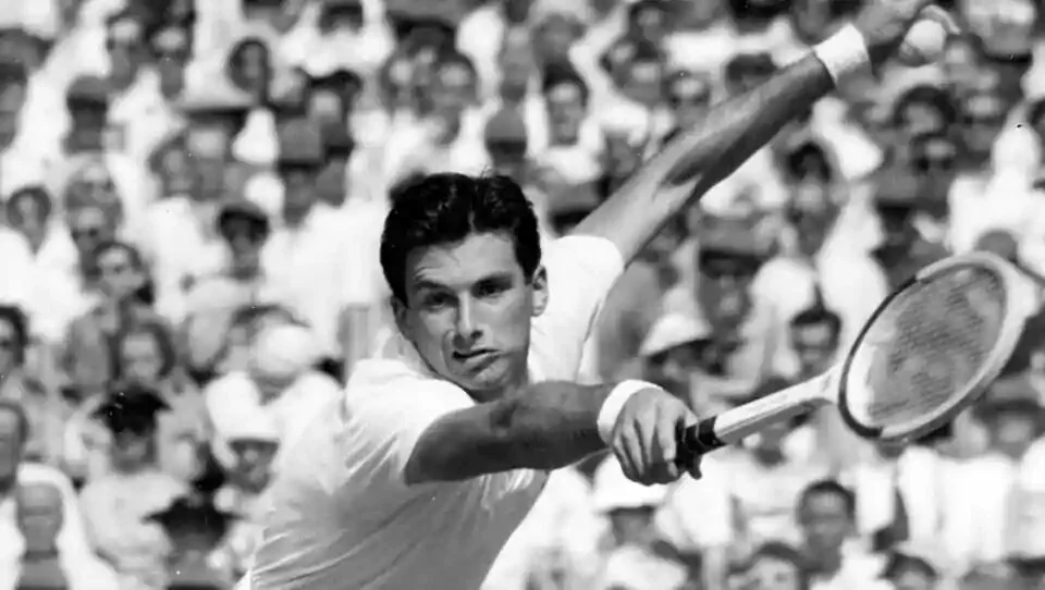 FILE - In this July 3, 1957, file photo, Australian tennis player Ashley Cooper leans forward to return service during his two-hour match against compatriot Neale Fraser at Wimbledon. Cooper, who won four Grand Slam singles titles including the Australian, Wimbledon and U.S. championships in 1958, has died. He was 83. Tennis Australia said Friday, May 22, 2020, that the former No. 1-ranked player and long-time administrator had died after a long illness. ((AP Photo/File)
