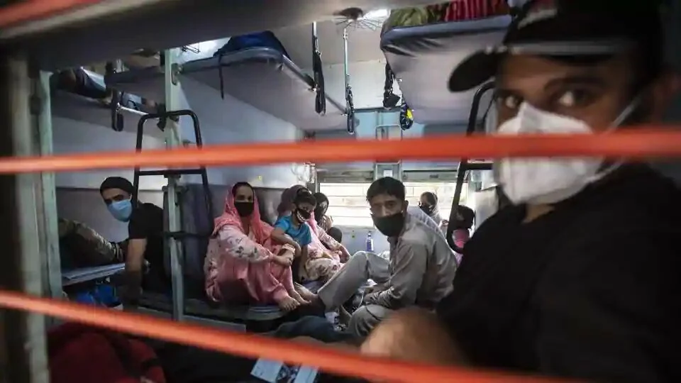 Stranded people sit inside a railway compartment before the train towards Jammu and Kashmir leaves from Pune railway station, India, on Tuesday, May 19, 2020.