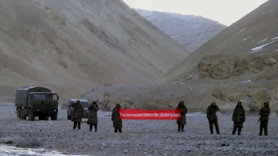 FILE - In this May 5, 2013 photo, Chinese troops in Ladakh hold a banner that asked Indian troops to move back