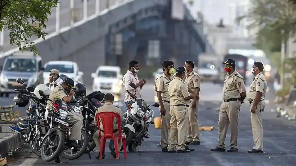 Police personnel stop migrants on their way back to reach native places on Eastern Express Highway, in Mumbai on Sunday.