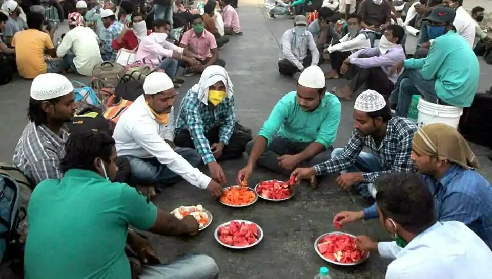 Migrants workers break their fast during the holy month of Ramzan waiting in a queue for special trains leaving for Bhagalpur in Bihar from Mumbai on Wednesday.