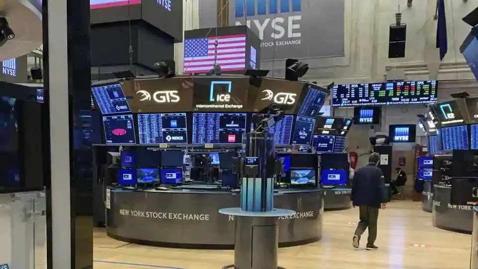 A trader walks across the partially reopened trading floor of the New York Stock Exchange on Thursday.