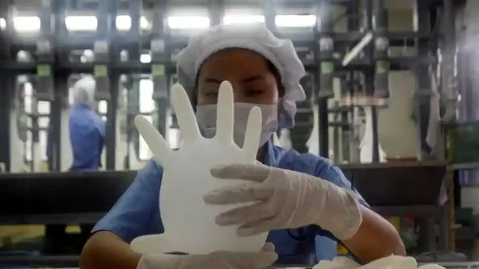 A worker carries out a test on a glove at a Top Glove factory in Meru outside Kuala Lumpur.