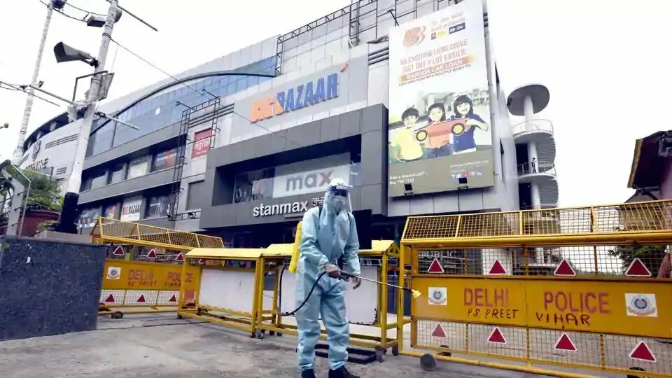 A worker wearing PPE sprays chemical disinfectant outside a mall in East Delhi’s Laxmi Nagar on Thursday.