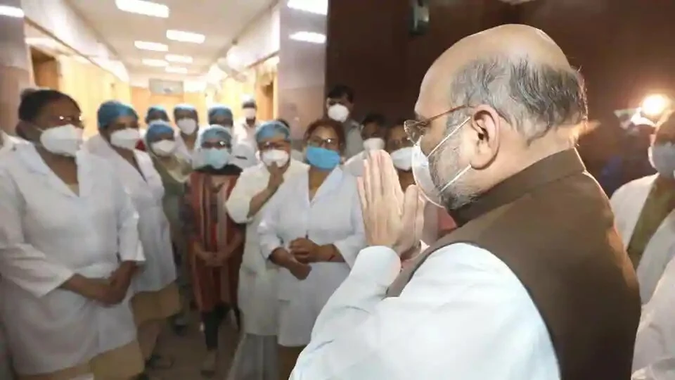 Union Home Minister Amit Shah gestures at the medical staff during his surprise visit to Lok Nayak Jai Prakash Narayan (LNJP) Hospital in New Delhi.