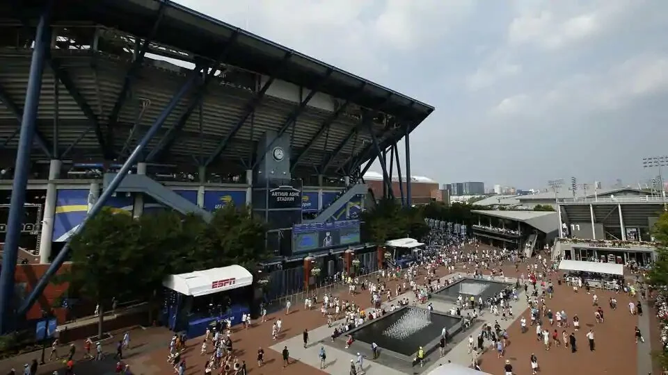 FILE - In this Aug. 27, 2018, file photo, fans walk outside of Arthur Ashe Stadium during the first round of the U.S. Open tennis tournament in New York. Governor Andrew Cuomo announced, Tuesday, June 16, 2020, that the U.S. Open will be played in Queens from Aug. 31 to Sept. 13, but without fans in attendance. (AP Photo/Jason DeCrow, File)