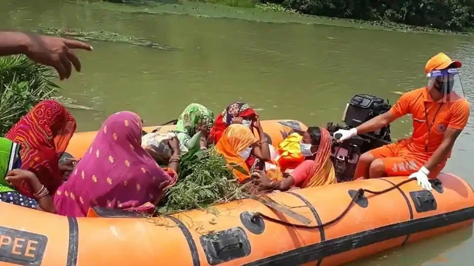 NDRF jawans helping flood affected people on a boat from flood area in Gopalganj, Bihar.