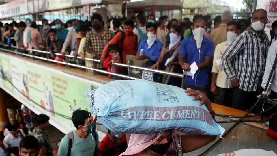 Migrants who returned from their hometown of Uttar Pradesh arrive to wait in line to be tested for the coronavirus disease (COVID-19) during a rapid antigen testing campaign at a railway station, on the outskirts of Mumbai.